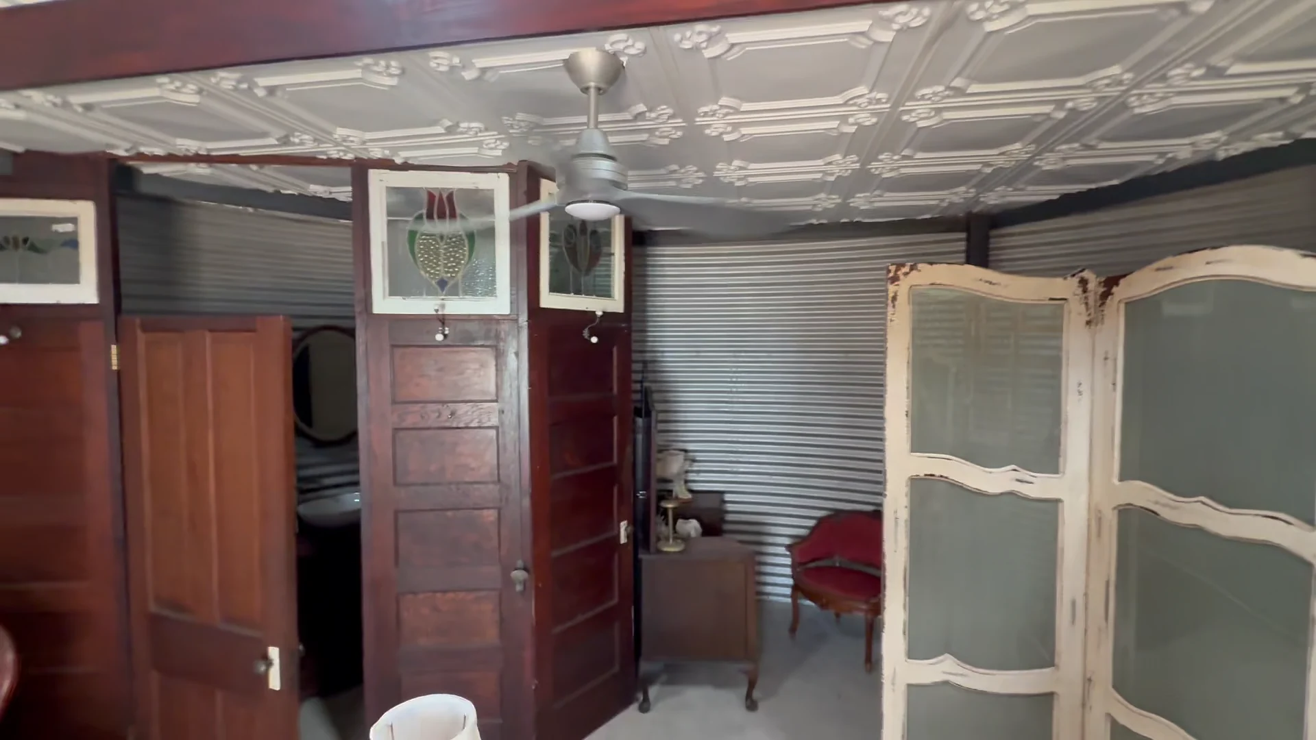 The grain-bin bridal suite with corrugated metal walls, vintage furnishings, and a decorative folding screen